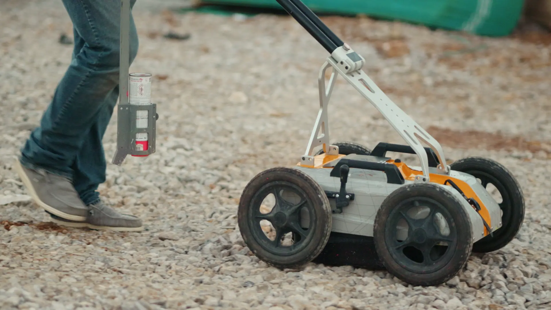 Close-up of a Utility Locators technician using a locating probe near excavation site materials